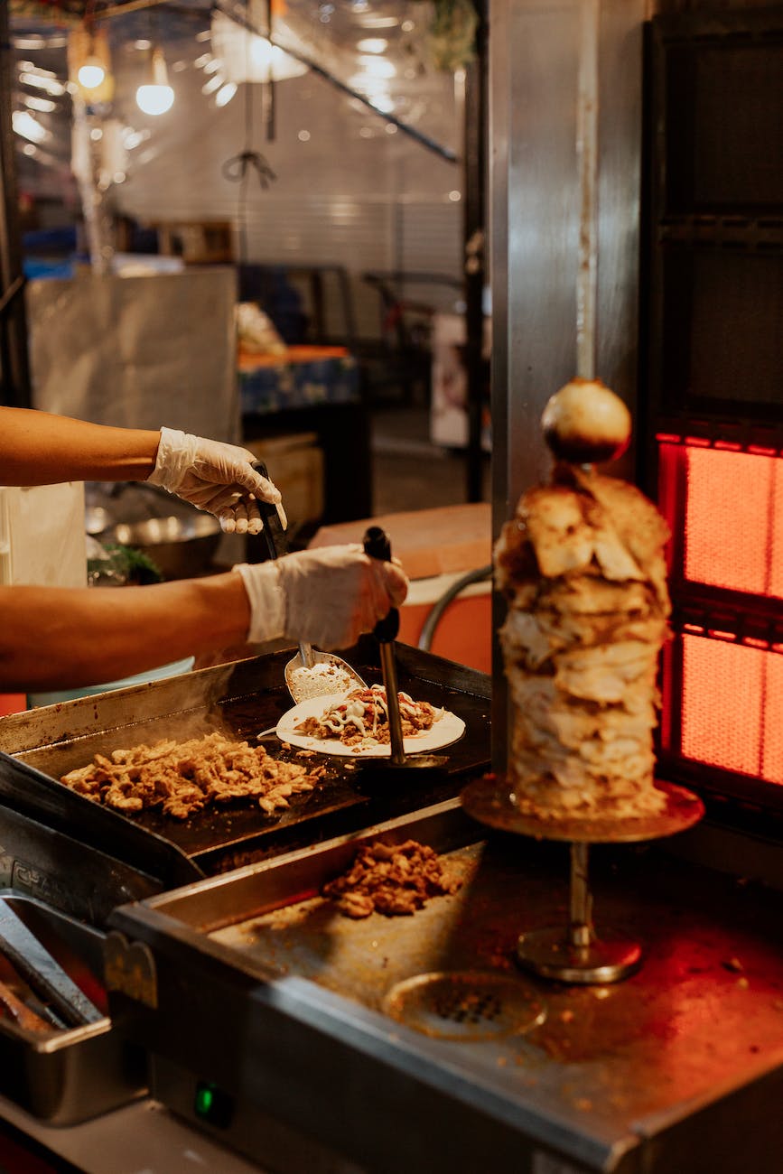 man in white apron holding stainless steel tray