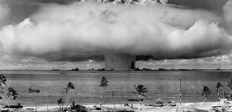 grayscale photo of explosion on the beach